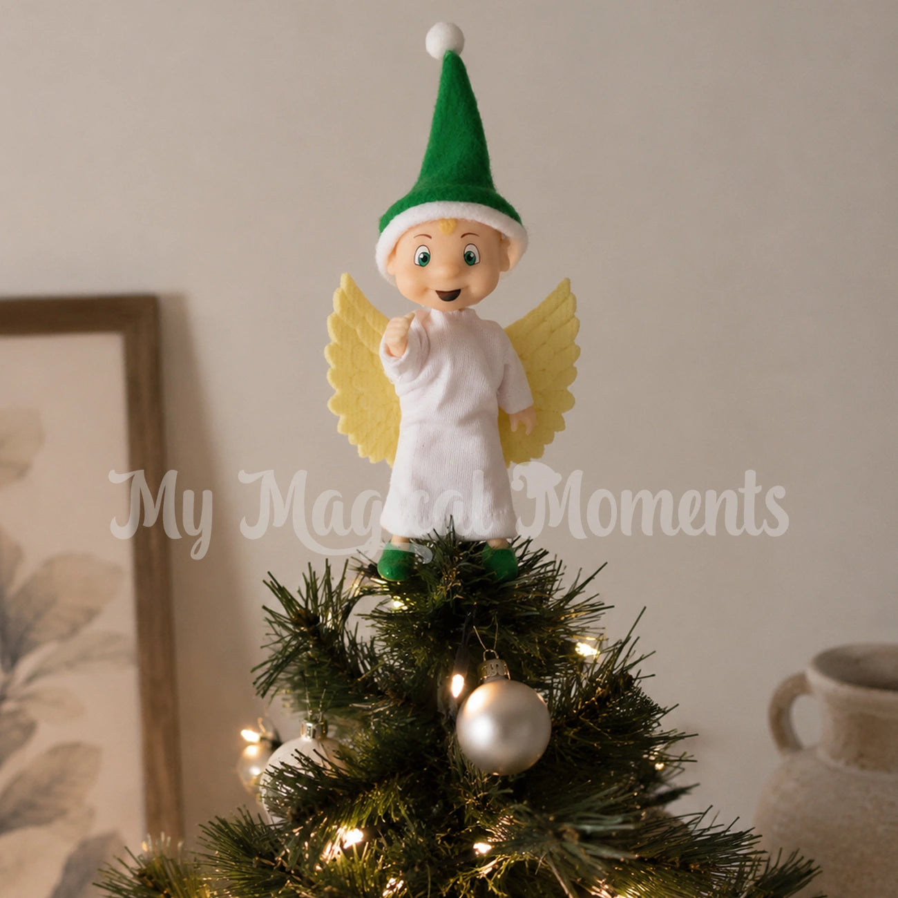 Elf toddler dressed as an angel on top of a Christmas tree
