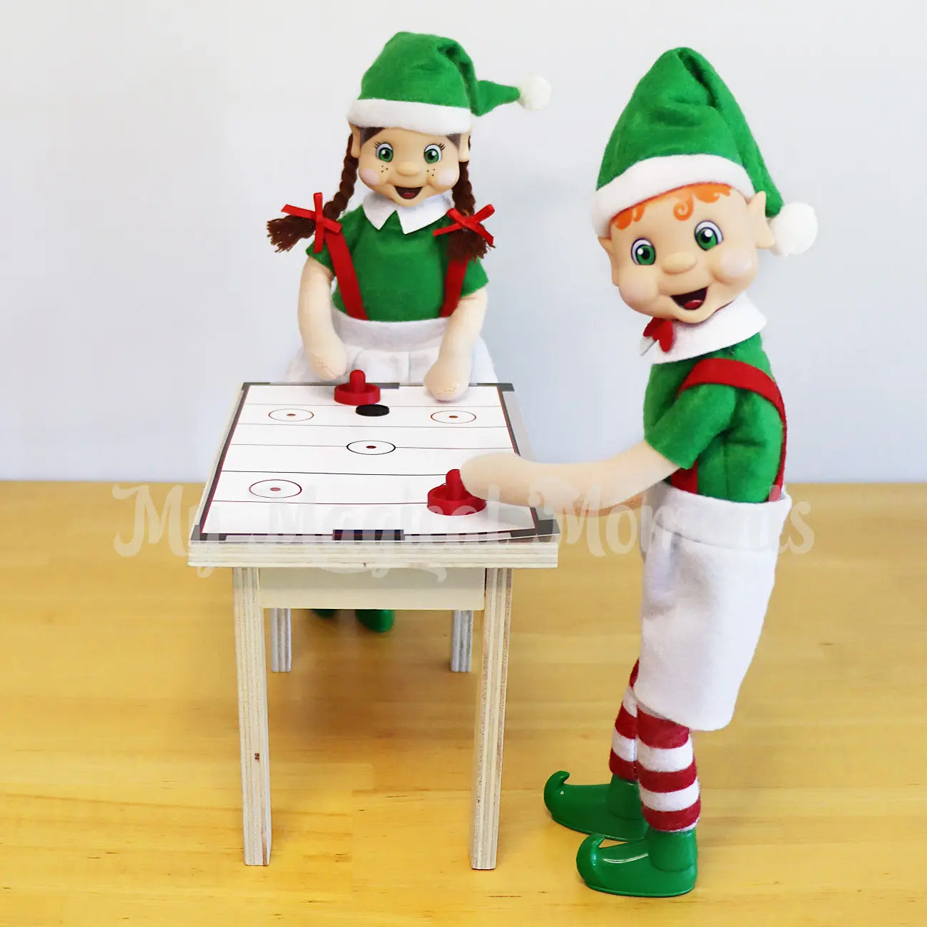 Elves playing with a mini air hockey scene