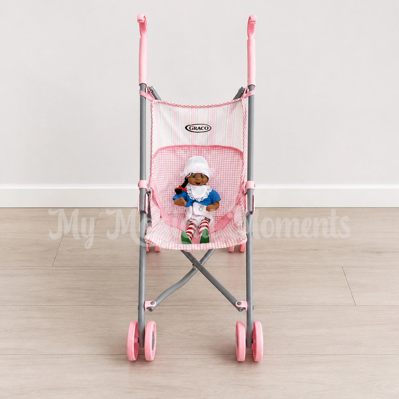 Elf dressed as a baby sitting in a pram
