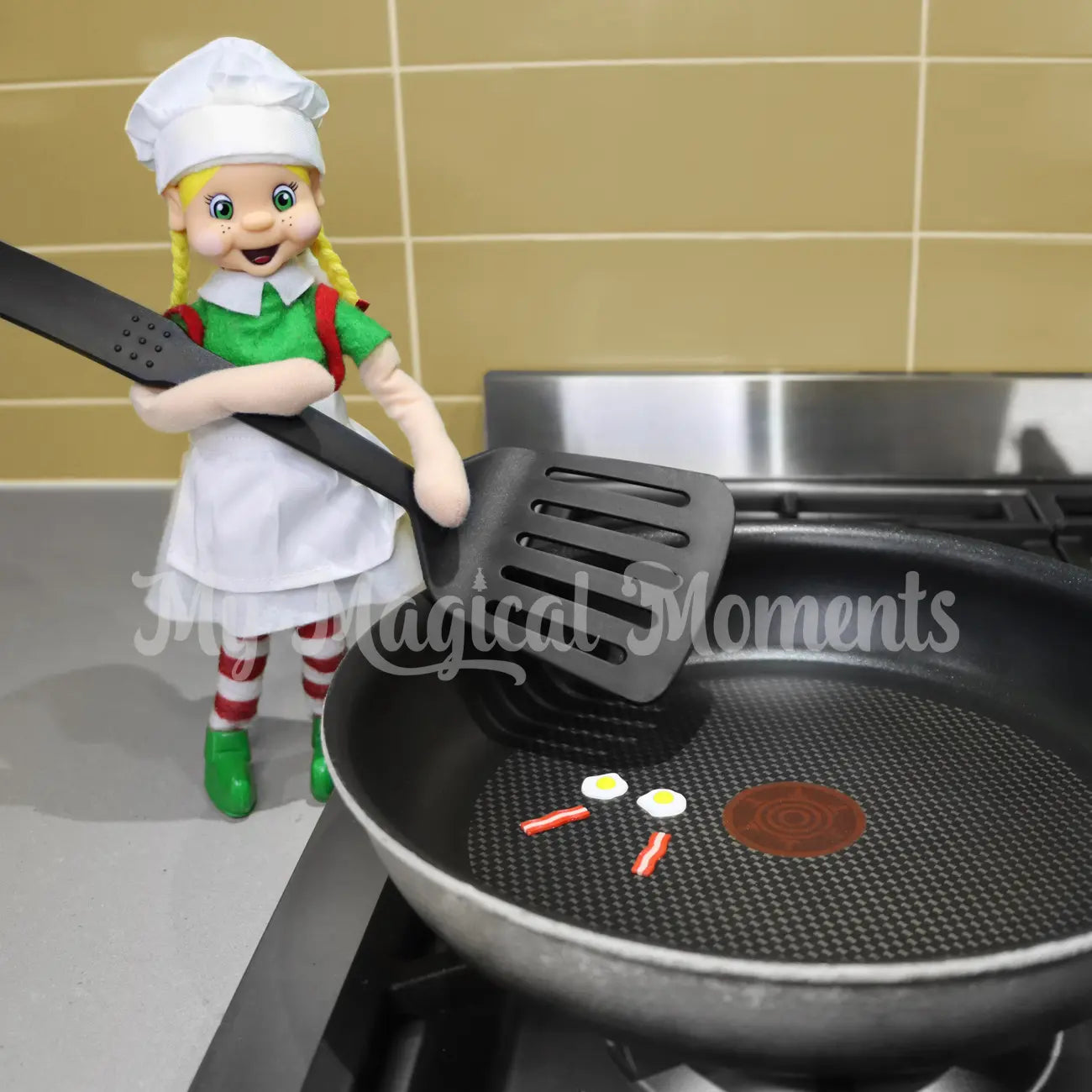 elf wearing a chef costume, cooking bacon & eggs mini props