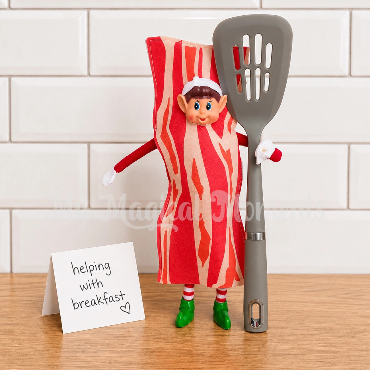 Elf wearing a bacon costume, holding a spatula with a little sign saying helping with breakfast