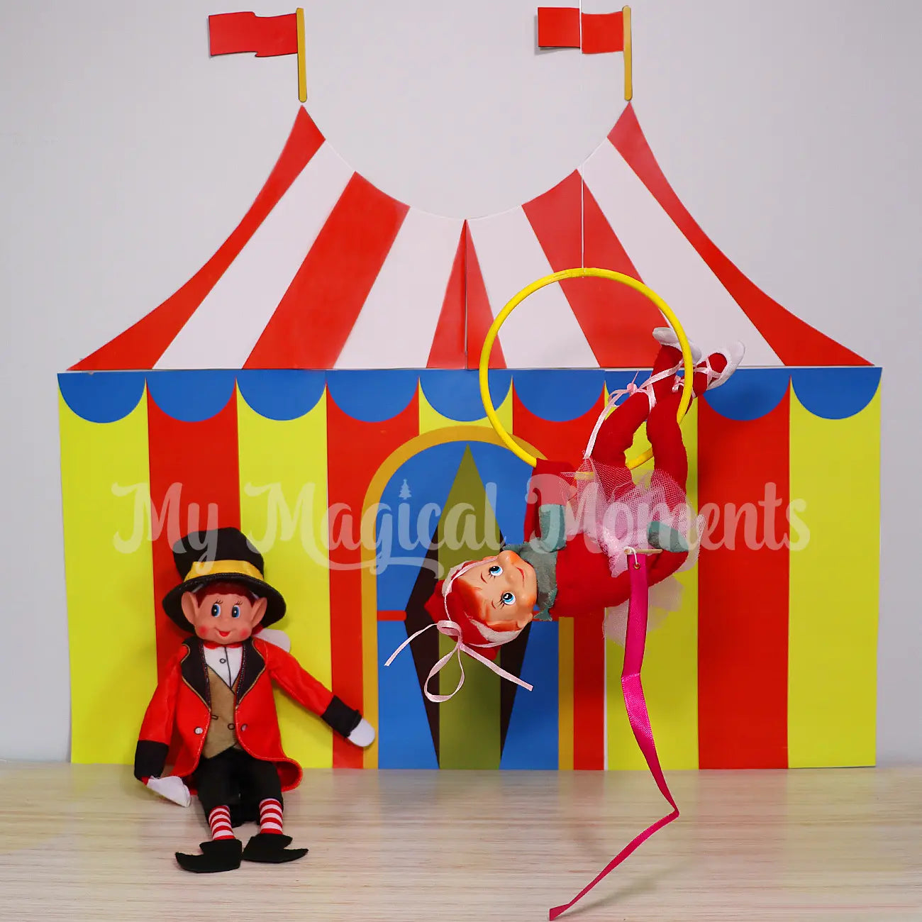 Circus Tent Printable With a Ballerina hanging in a hula hoop with an elf dressed as a circus ring leader
