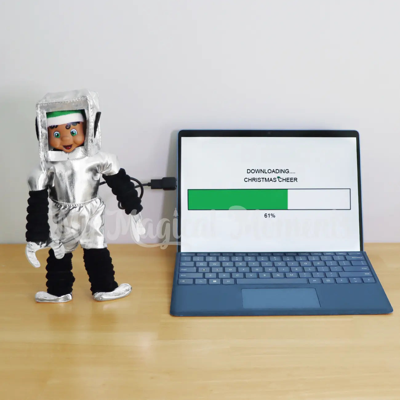 Black hair My Elf Friends standing wearing a robot costume, downloading Christmas cheer on a laptop