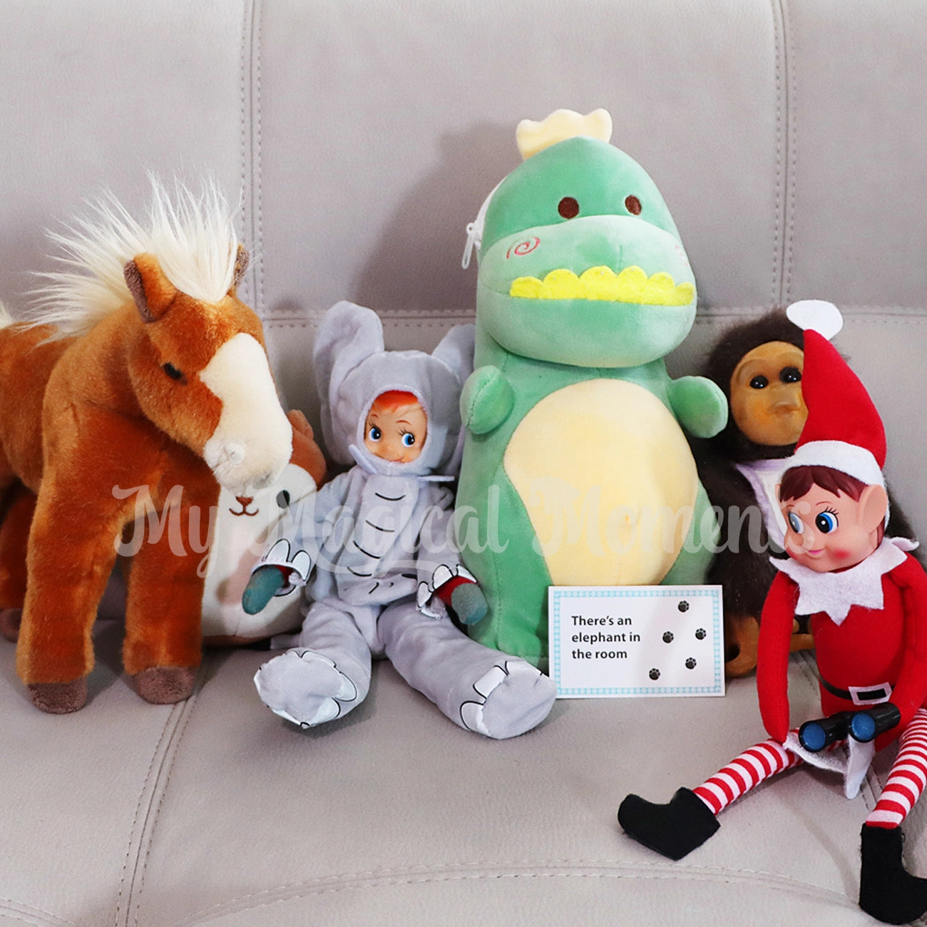 Collection of plush toys including a horse, elephant costume worn by an elf, dragon, and elf on a couch holding mini binoculars