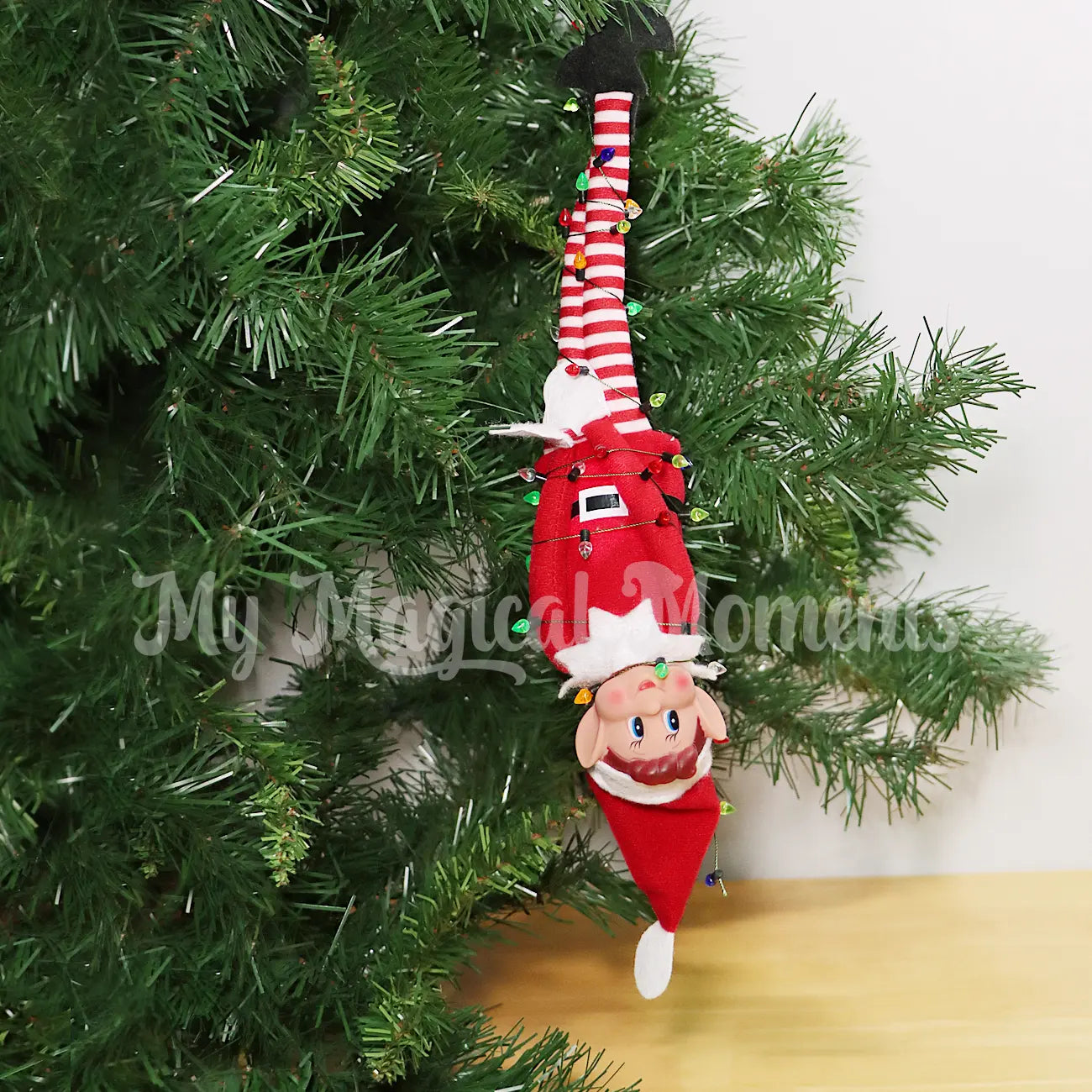 Elf caught in mini Christmas Lights hanging from a Christmas tree