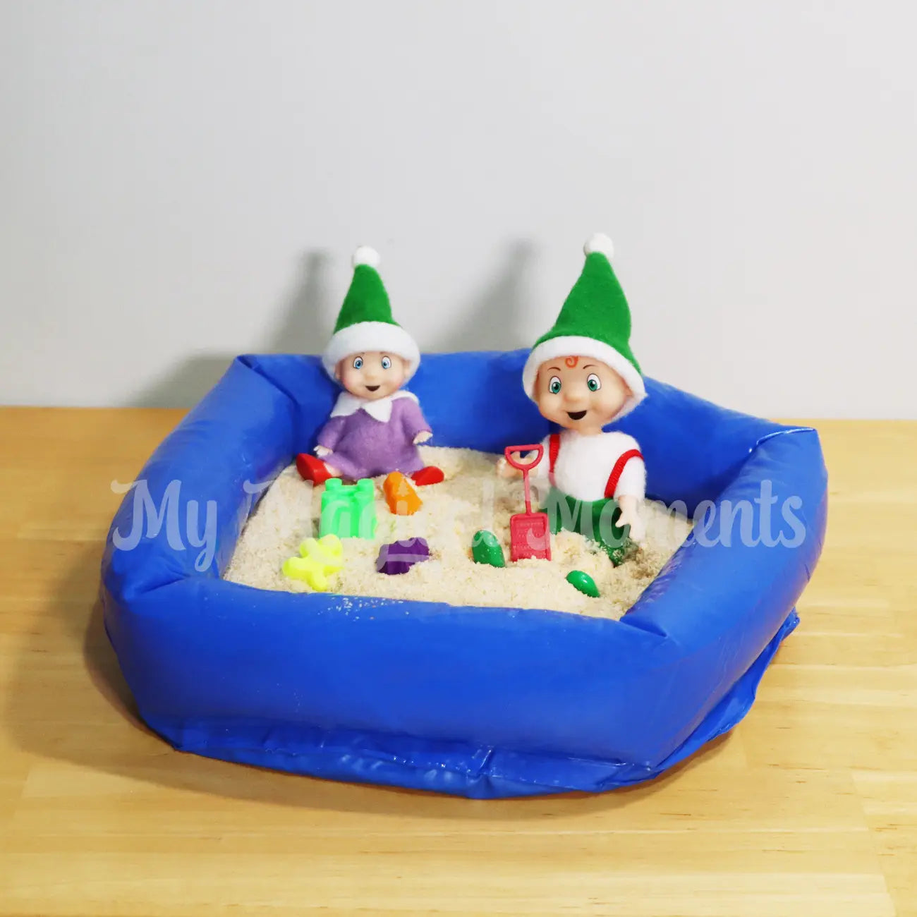 Baby Elf and orange hair toddler elf playing in an inflatable sand pit with sand toys