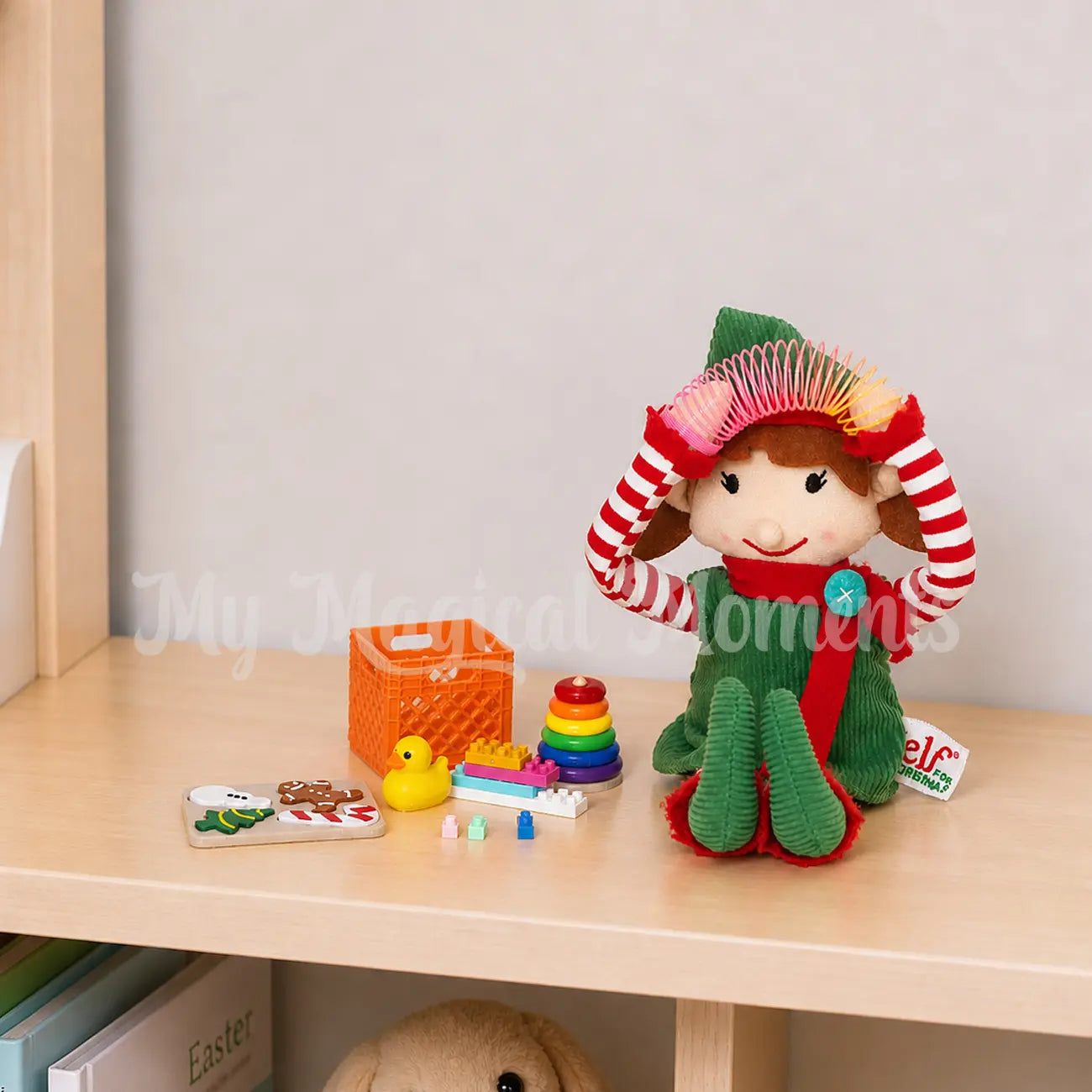 Elf playing with a mini slinky and other elf toys, mini lego, rubber ducky, puzzle, ring toss and mini crate