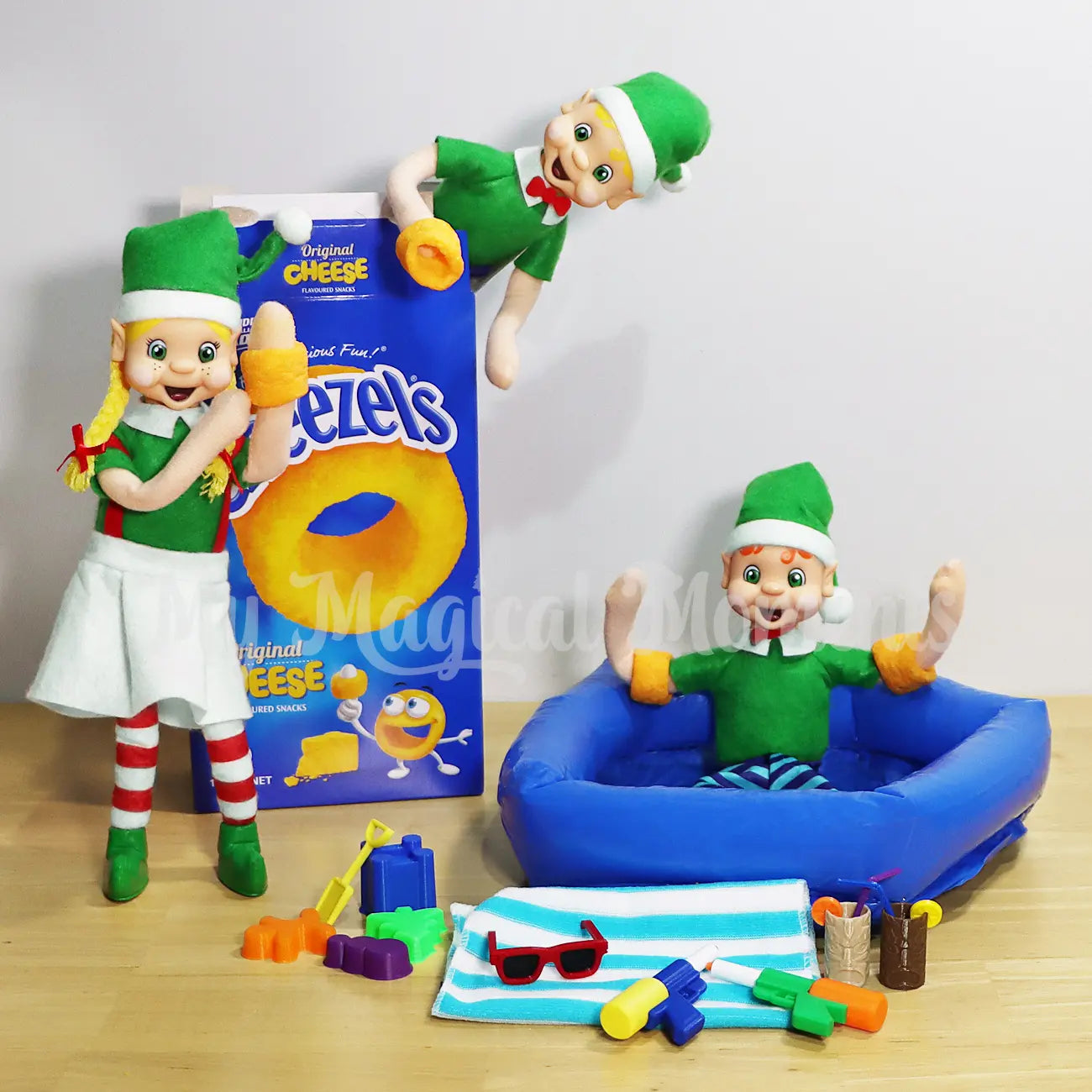 Elves wearing Cheezels as Floaties in a mini inflatable pool having a pool party, with sunglasses, pool toys, water guns and tiki cups