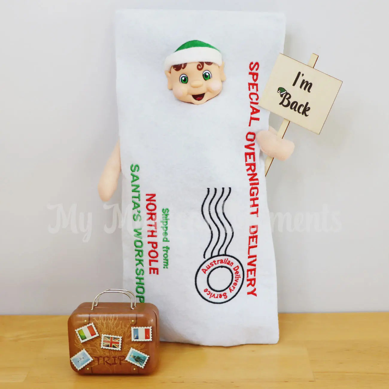 elf wearing a envelope arrival costume with miniature suitcase and im back sign