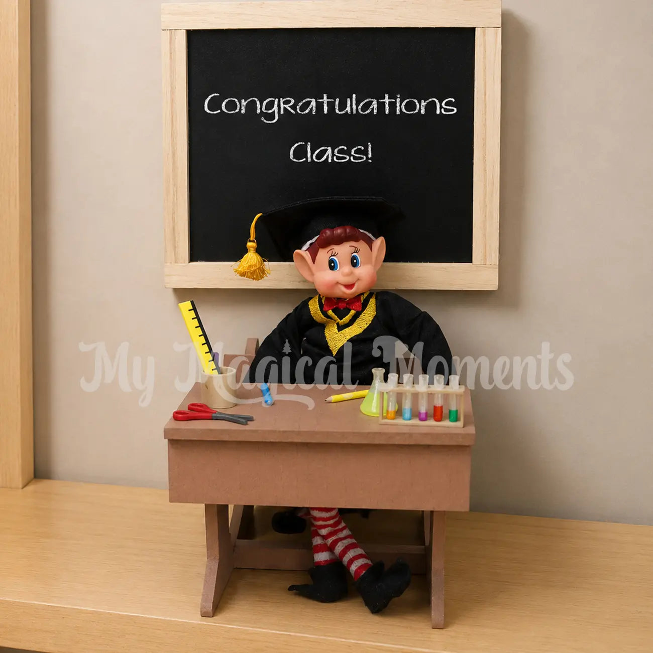 Elf wearing a graduation outfit graduating end of class in his little desk