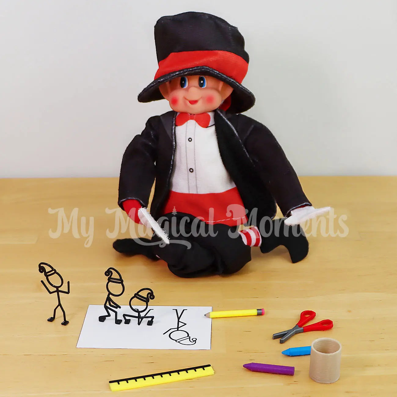 Elves behavin badly elf dressed as a magician with mini stationery set drawing stick figures and they come to life