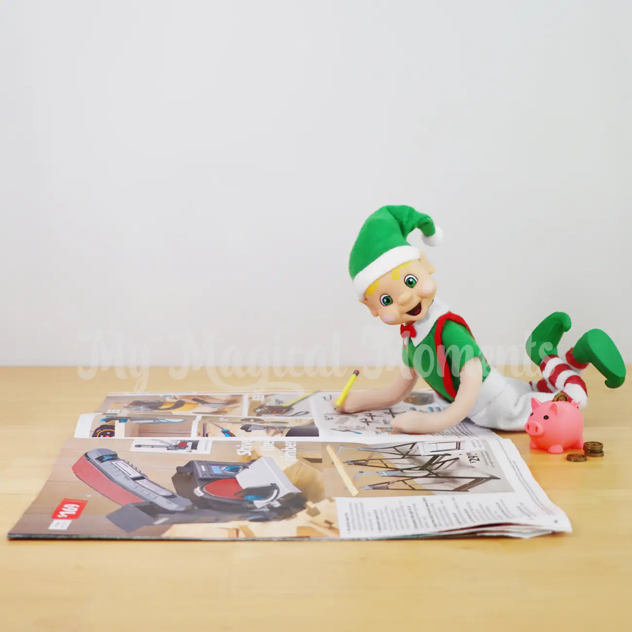 My Elf Friend Blonde Hair Bendable Elf circling things in a catalogue with mini piggy bank prop