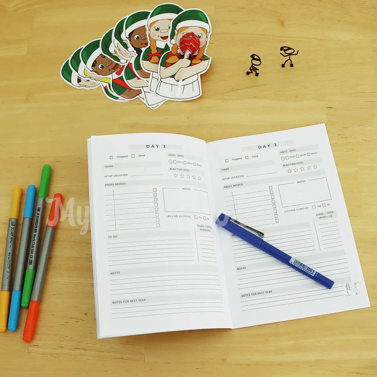 Elf Visit Planner On a table with lollipop holder Elf Friends and pens