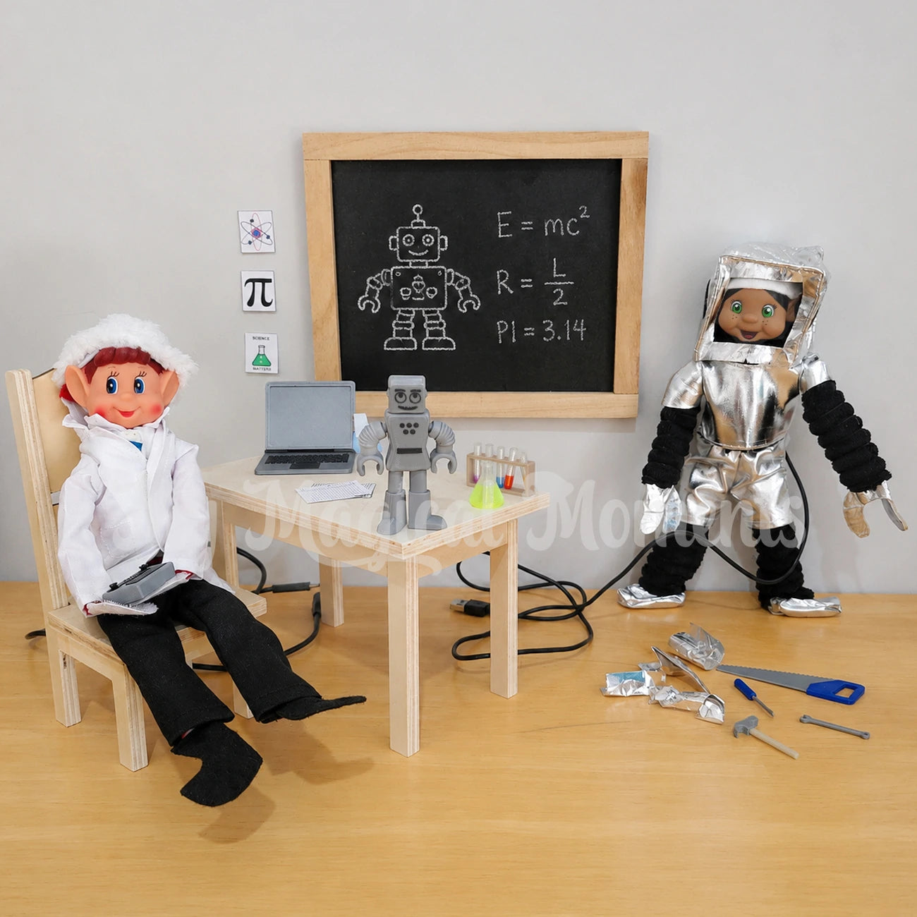 elf dressed as a scientist, doing experiments building robots, there is a black hair elf standing wearing a robot costume, mini tools on the ground with cables. A mini table and chair set with a robot, chemistry set, laptop, a chalkboard with a robot equation in chalk