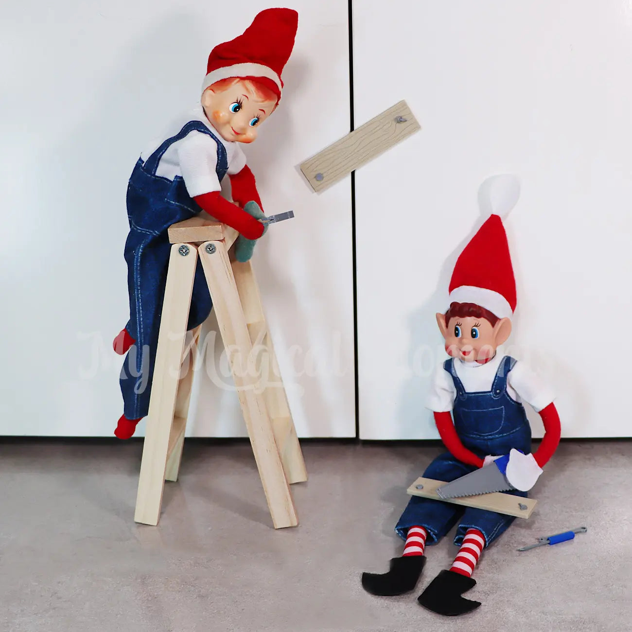 Elves wearing overalls closing up the cupboard with mini planks of wood with a ladder and mini tools