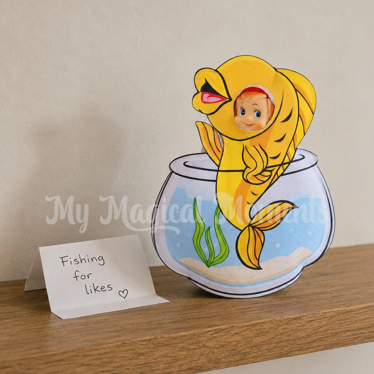 Elf wearing a fish bowl costume with a sign saying fishing for likes