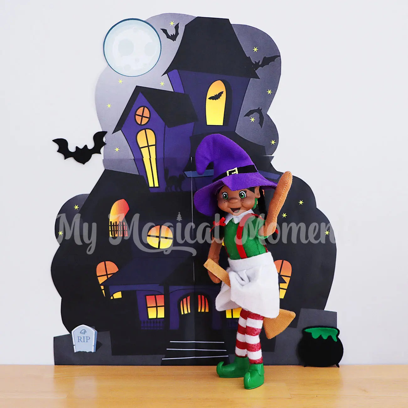 Elf dressed as a witch on broomstick in front of haunted mansion