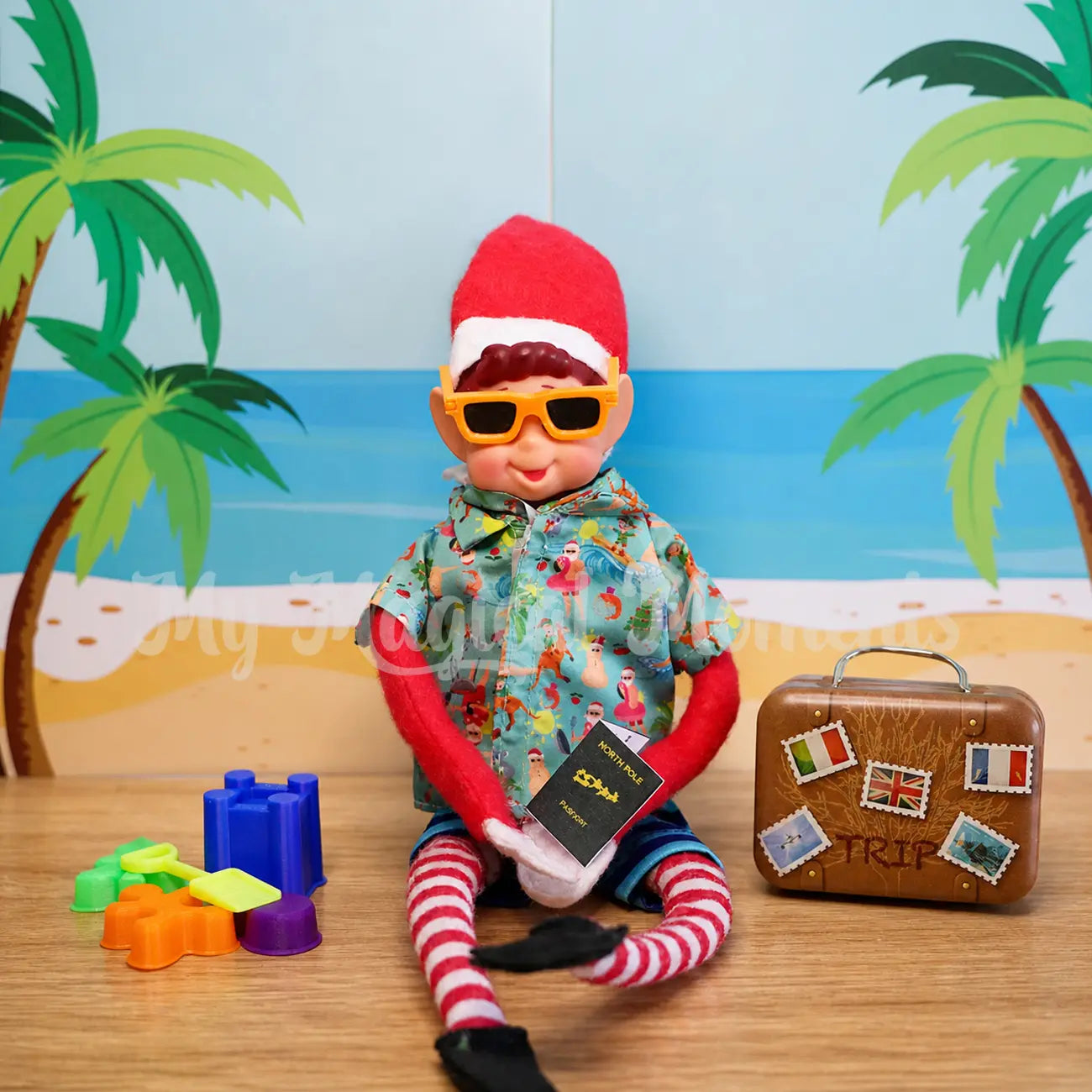 Elves behavin badly elf wearing mini sunnies and an hawaiian shirt with beach toys and a suitcase