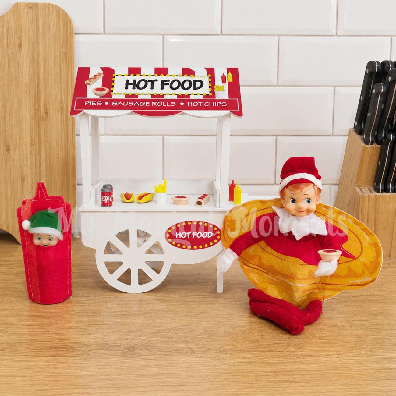 Hot food stand with mini elf food with an elf wearing a pie costume