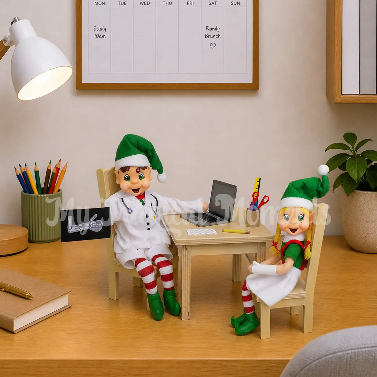 Broken arm scene, With a elf dressed as a doctor tending to a blonde hair elf with a broken arm. He has a elf sized laptop and pencils on his desk