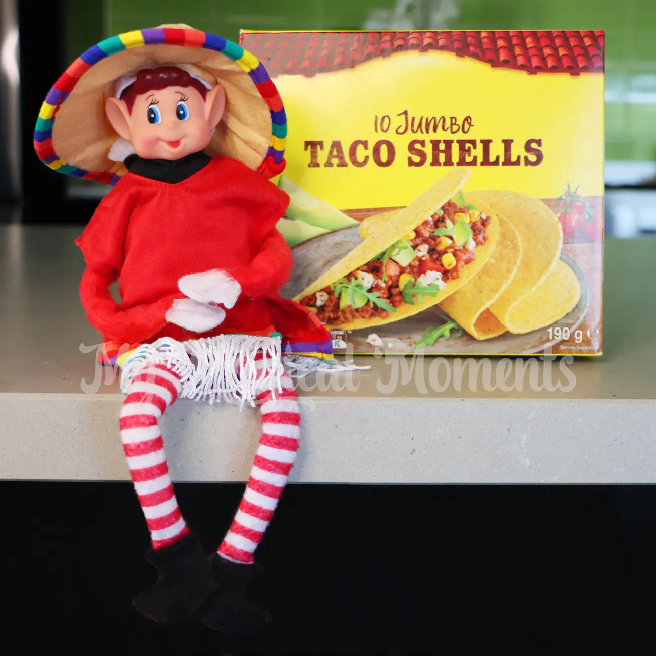 Elf wearing a Mexican outfit in front of a taco shelf