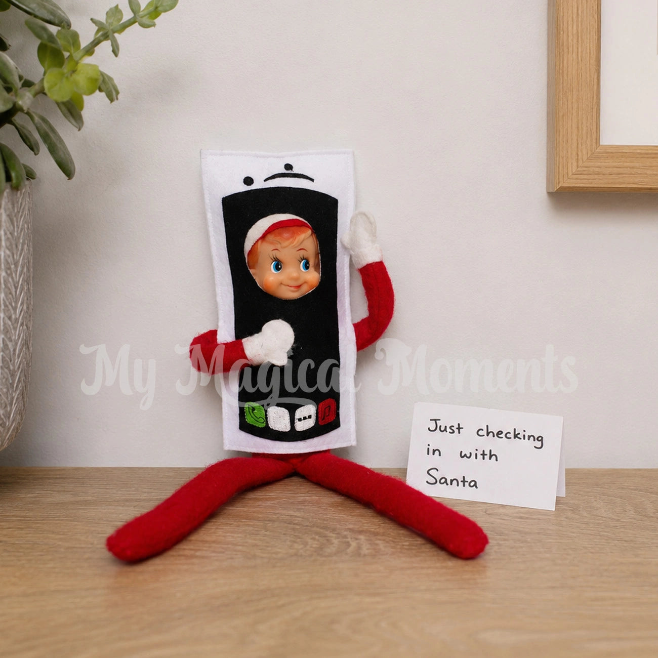Elf wearing a mobile costume, with a note saying just checking in with santa. on a bench