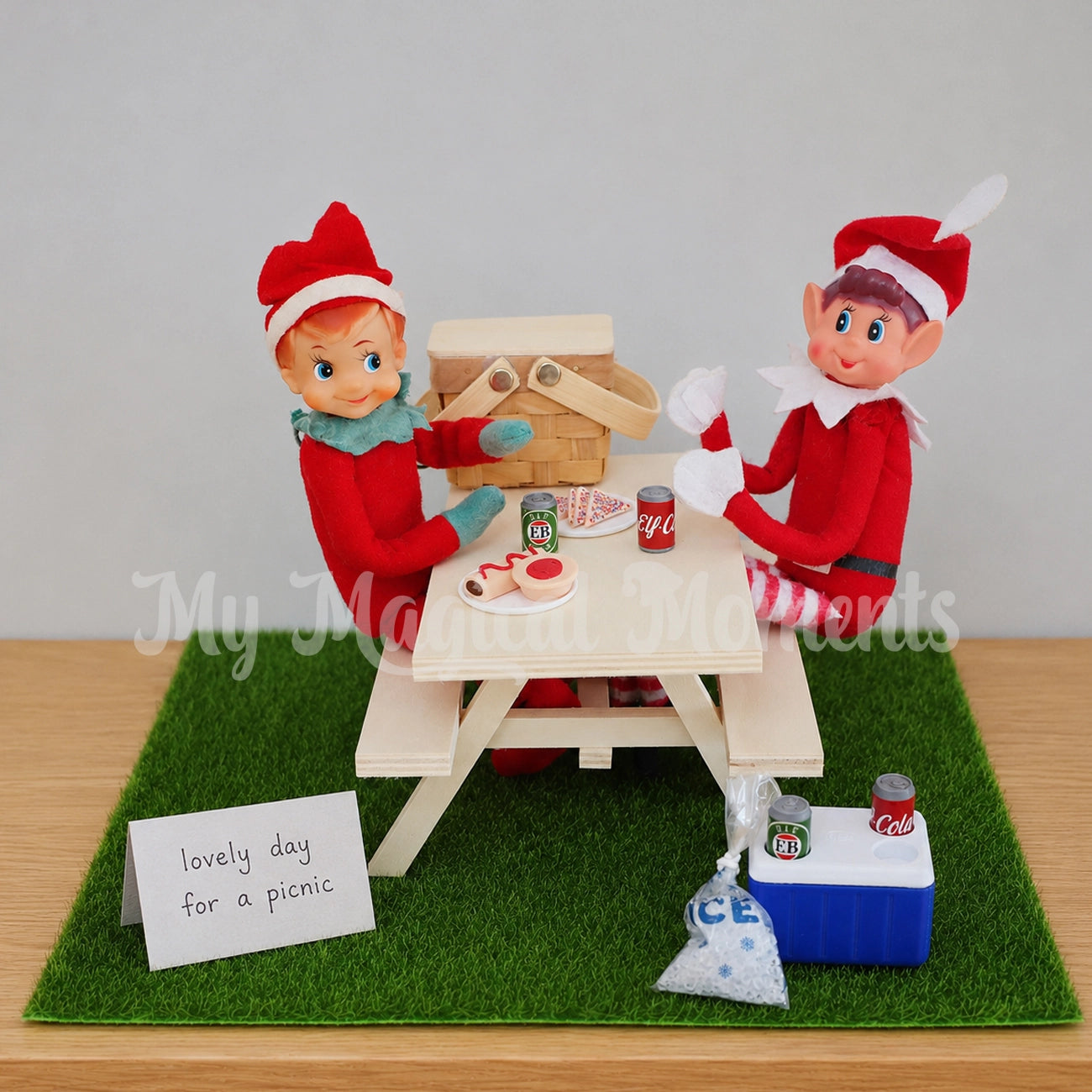 Elf having a picnic under the Christmas tree, with picnic basket and mini cola and beer