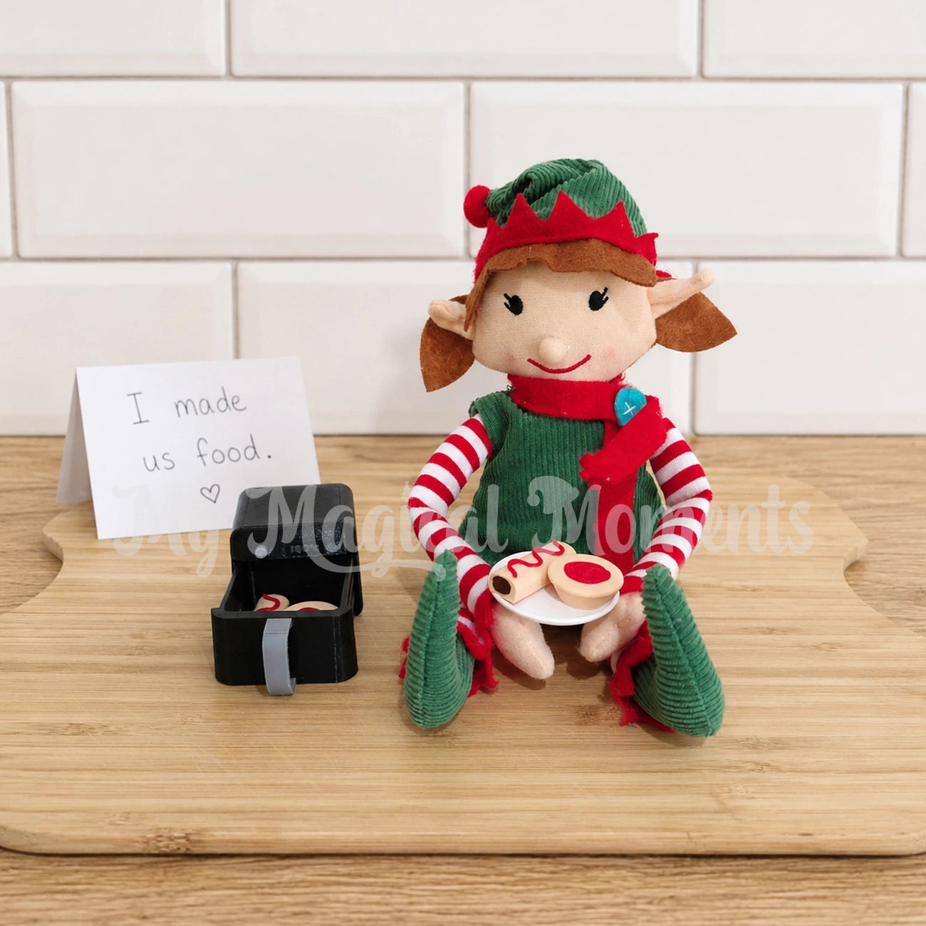 Elf using a mini air fryer prop with meat pies, sausage rolls on a mini plate
