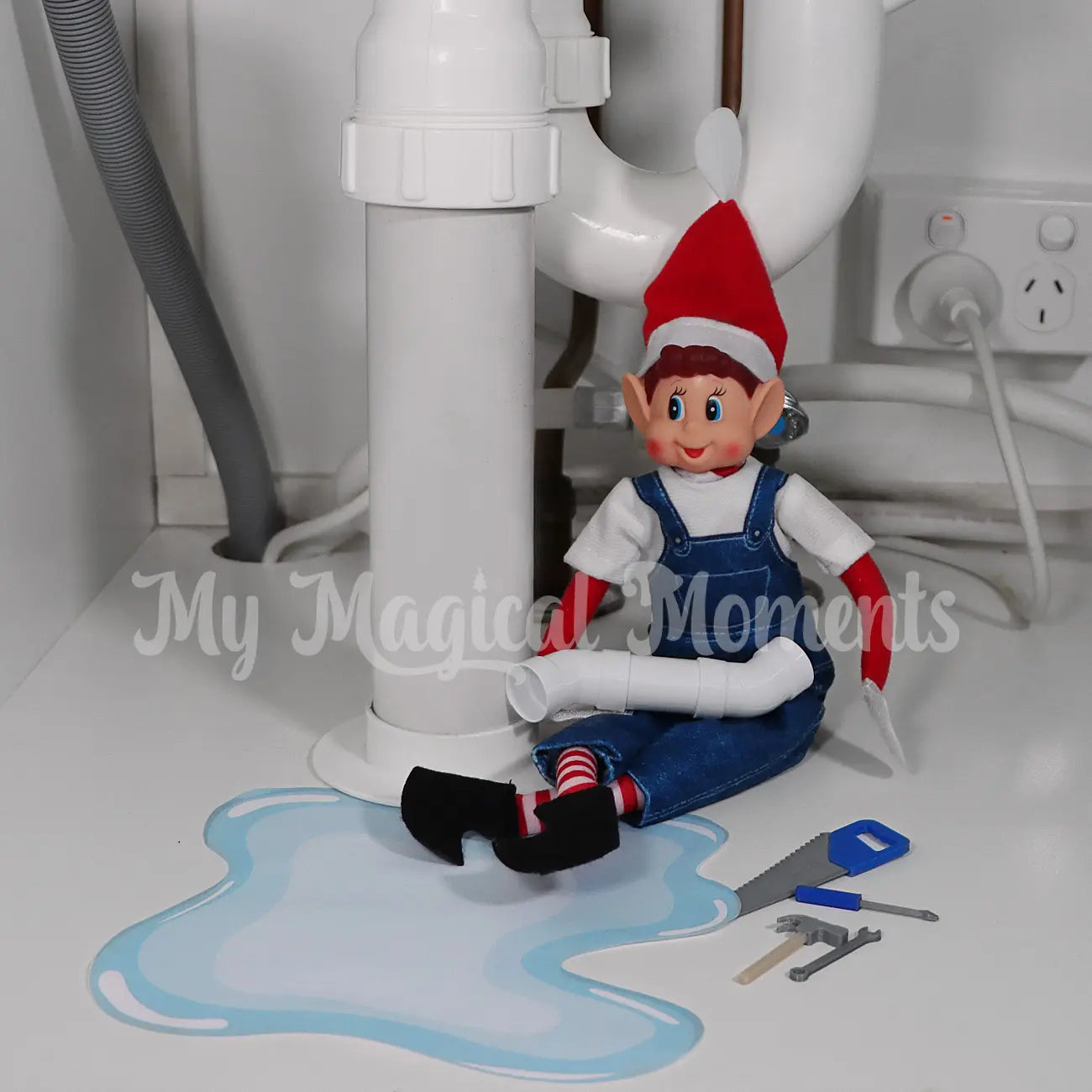 Elf Dressed in overalls fixing the sink with mini pipes and min elf sized tools