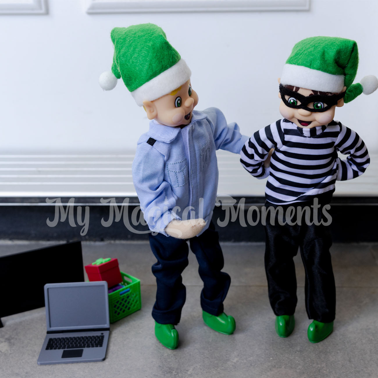 elf dressed police arresting a burglar elf with mini props