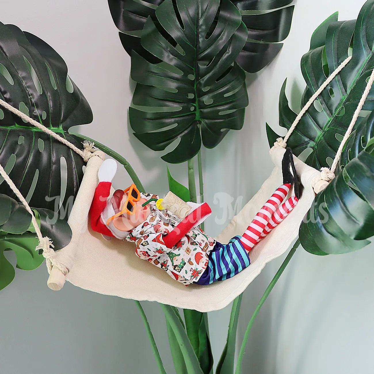 An elf wearing sunnies dressed in a hawaiian shirt and boardies drinking a tiki cup laying in a hammock on a plant inside the house