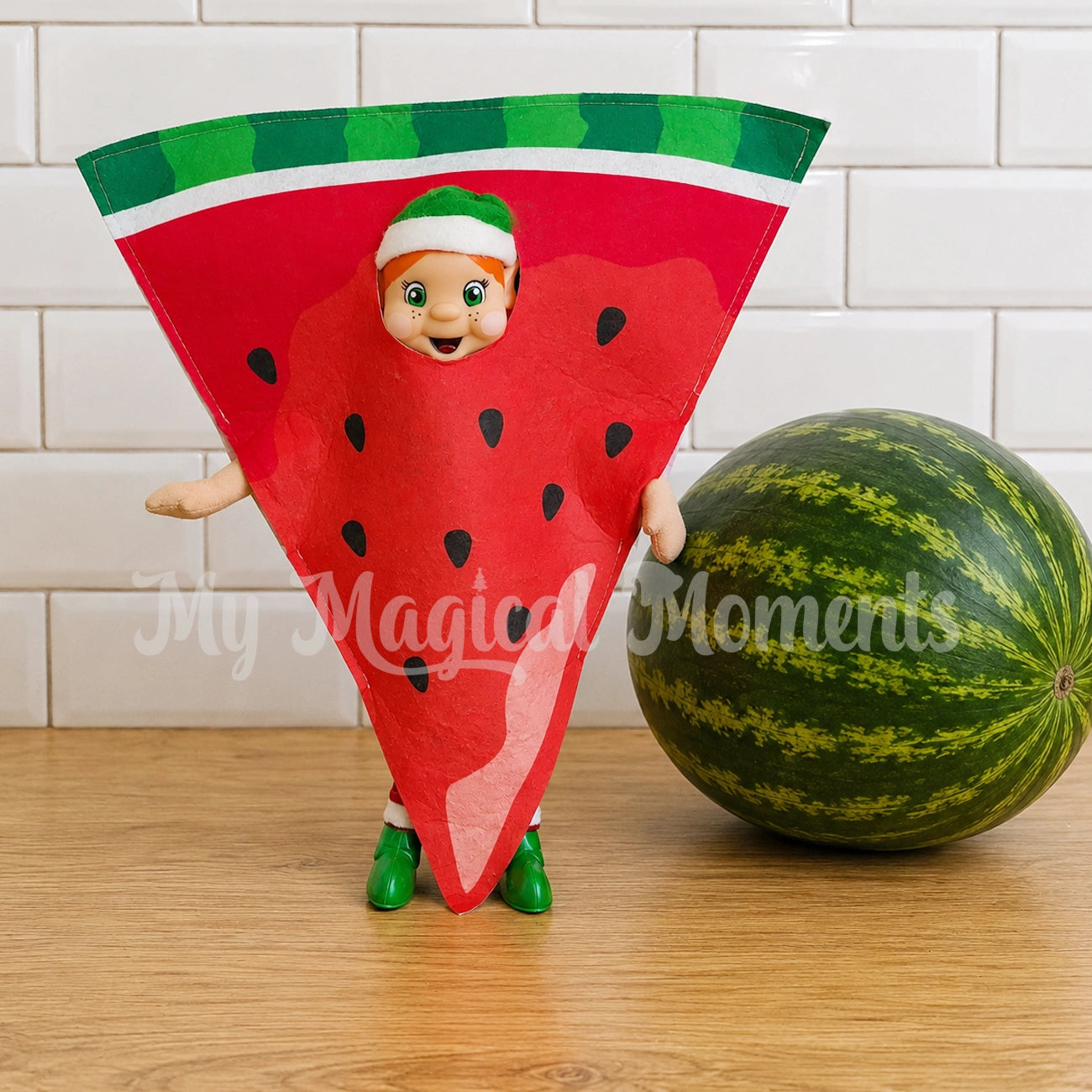 Orange hair My Elf friend dressed as a slice of watermelon in front of a whole watermelon