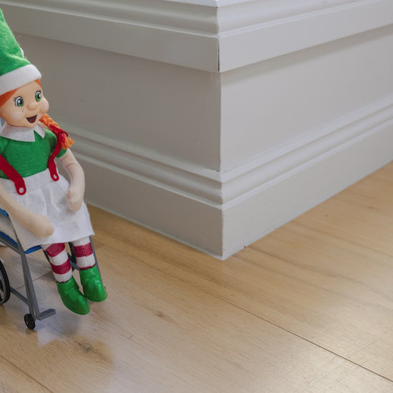 elf dressed as a nurse pushing an elf in a wheelchair