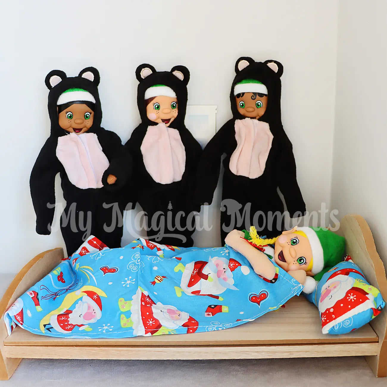 3 elves wearing bear costumes playing out goldilocks in bed