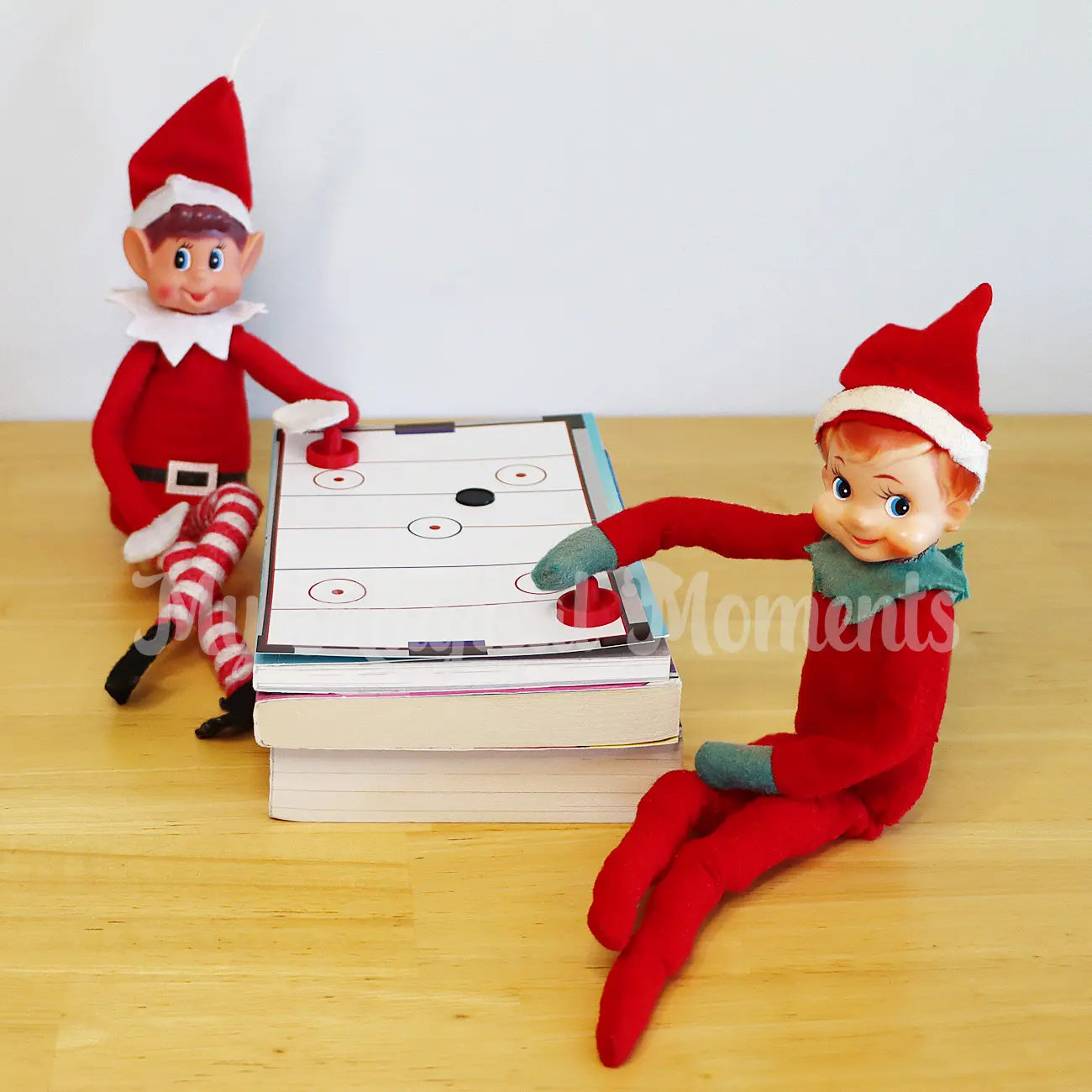 elves playing with a mini air hockey table and accessories