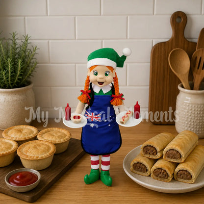 Elf wearing a bbq apron holding miniature pies and sausage rolls on a plate with tiny sauce bottles