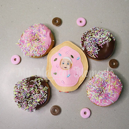 Elf baby dressed as a donut with mini donuts