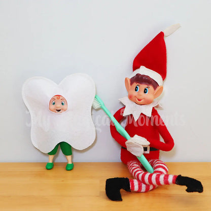 Elf toddler wearing a tooth costume, being brushed by an elf