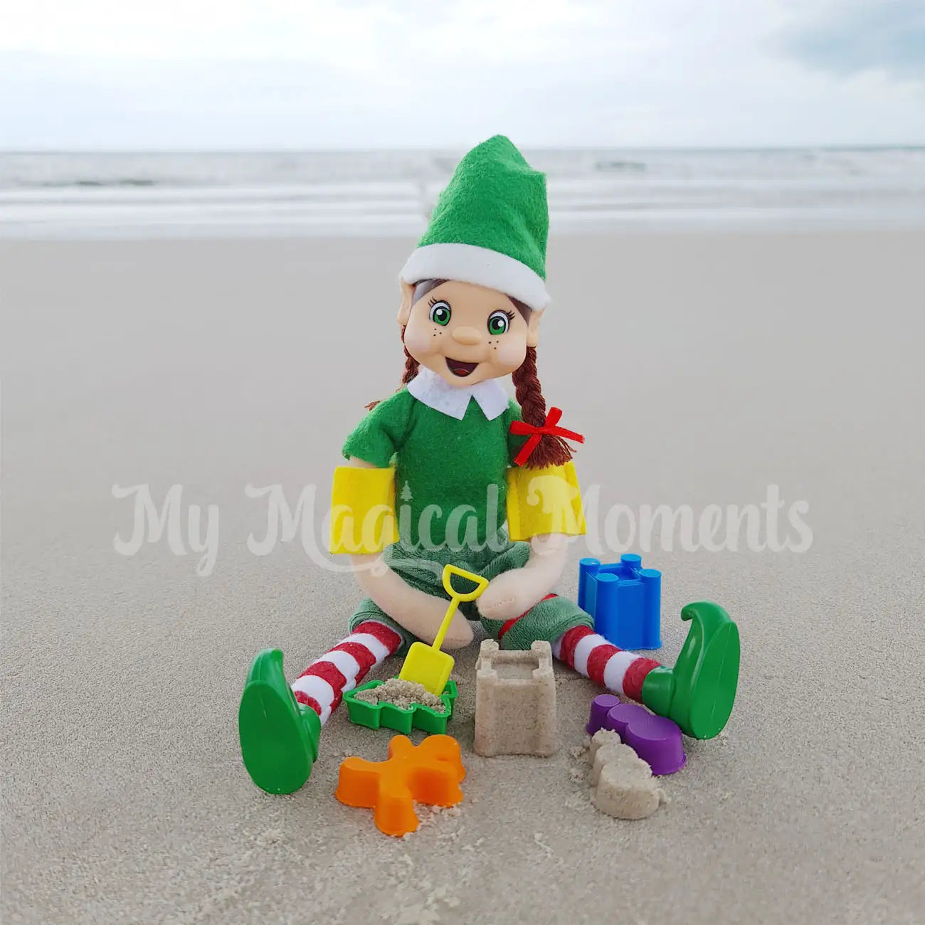 elf on the beach playing with her sand toys