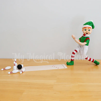 Elf bowling pins down with miniature bowling pins and ball