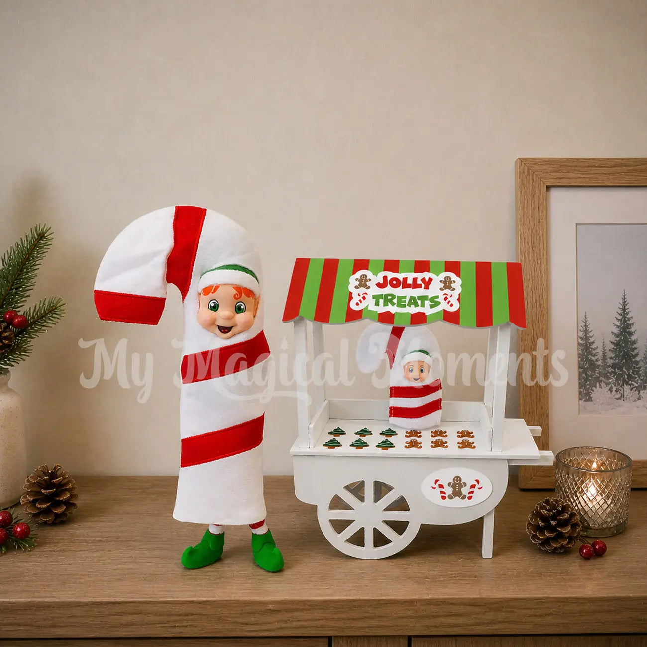 elf dressed as a candy cane selling gingerbread cookies, with a baby elf candy cane