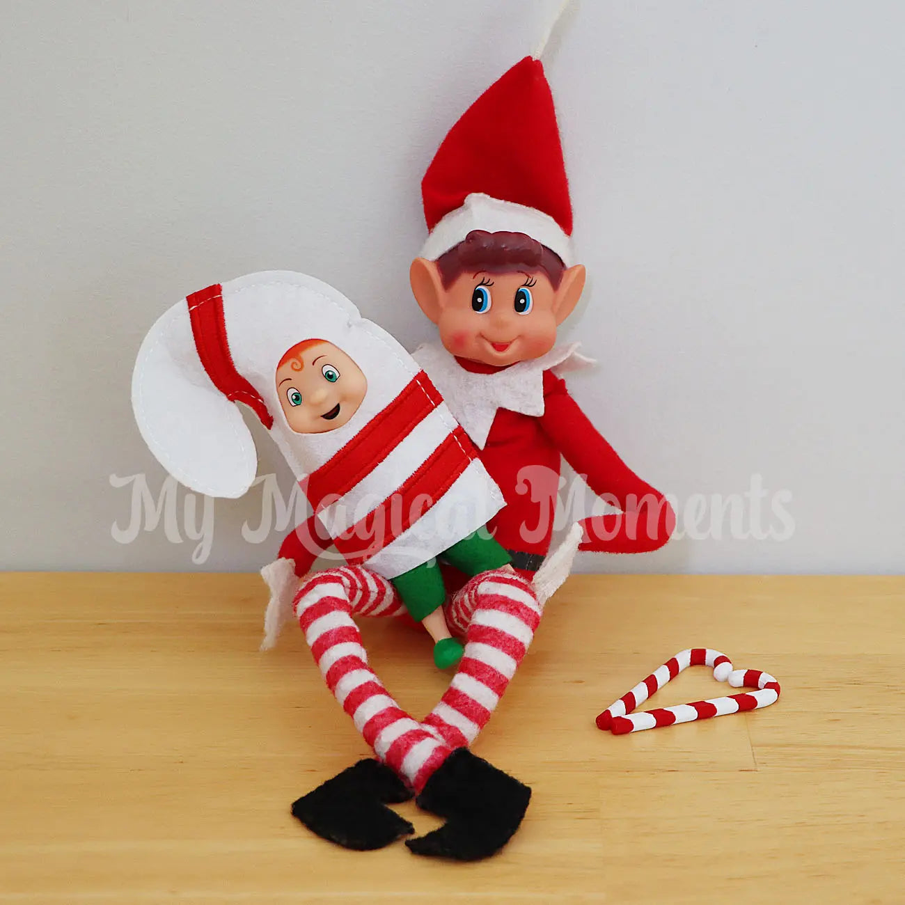 Elf toddler wearing a candy cane costume with mini candy cane accessories