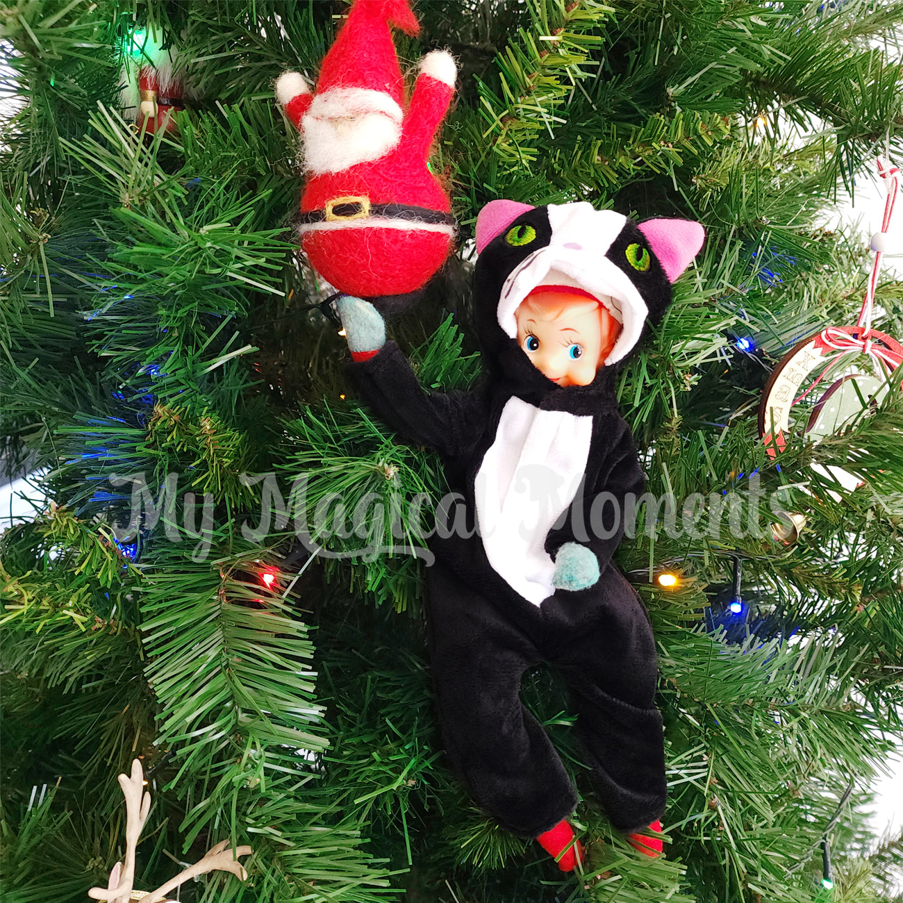 Elf dressed as a cat playing in the Christmas tree