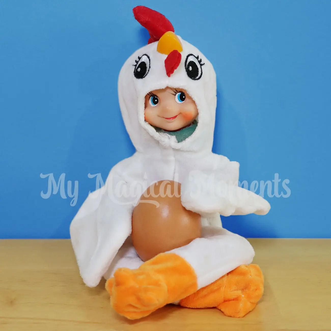 Elf dressed as a chicken holding an egg in the kitchen