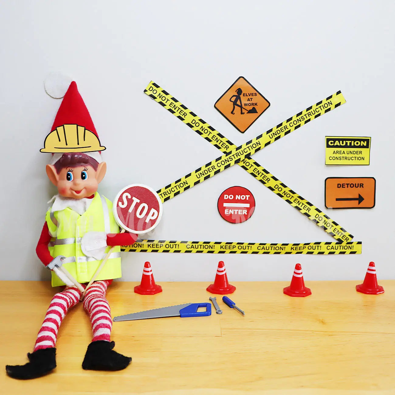 Elf wearing a road workers costume doing construction with tiny tools and free construction printables