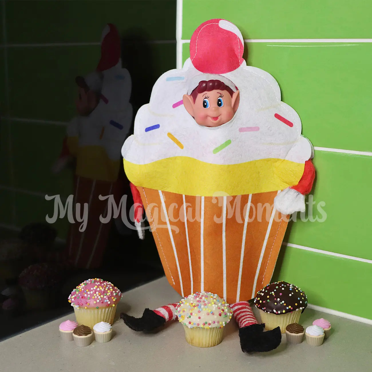 elf wearing a cupcake costume with mini elf cupcake props