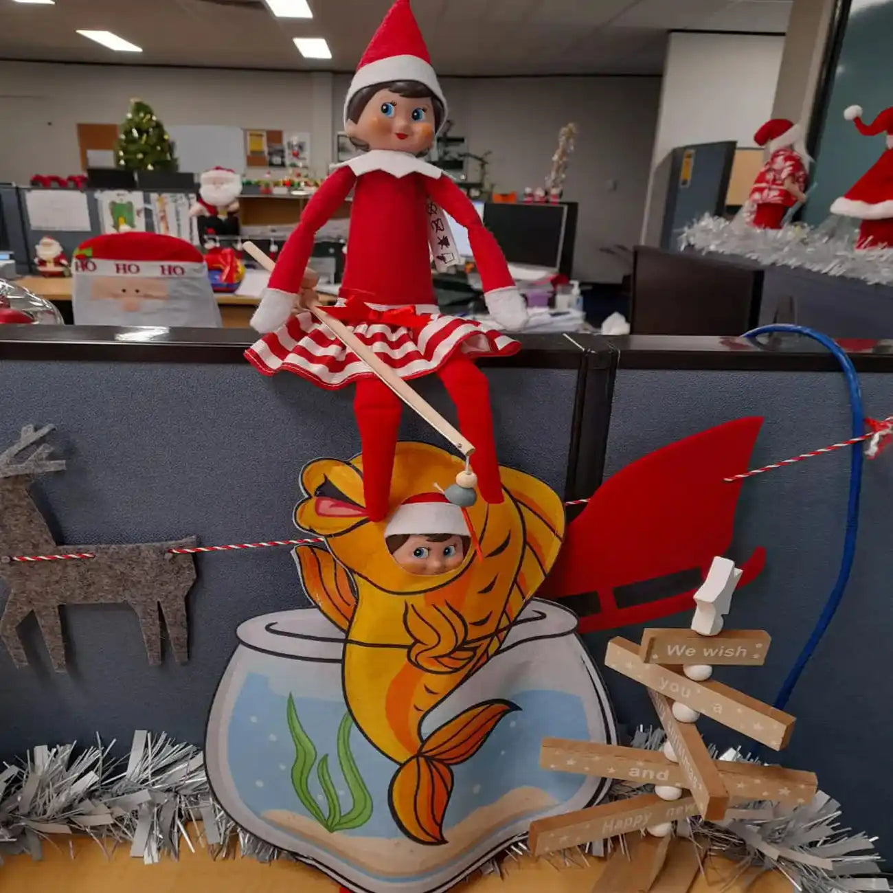 Elf on the shelf fishing with a fish customer by a customer