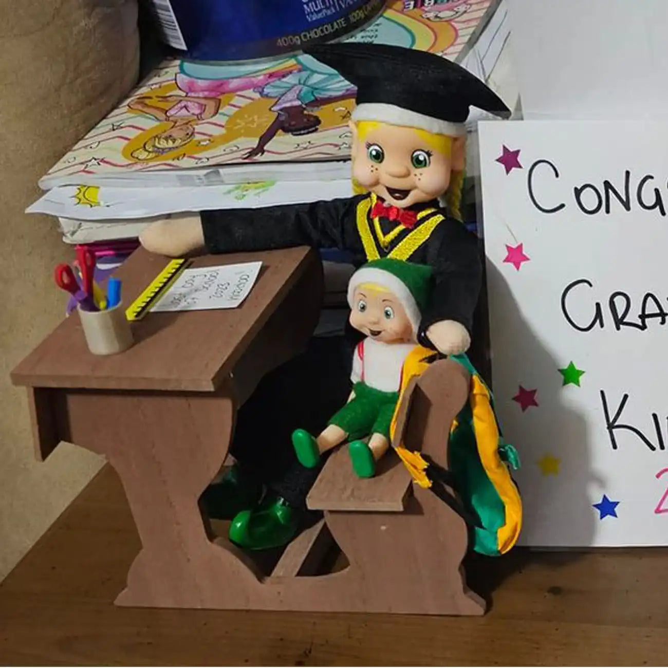 School desk with a elf dressed in a graduation costume customer photo