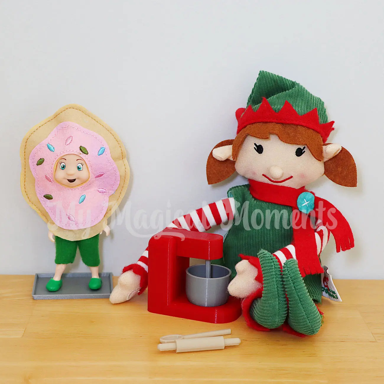 Elf toddler wearing a Donut costume, being baked by an elf with baking set