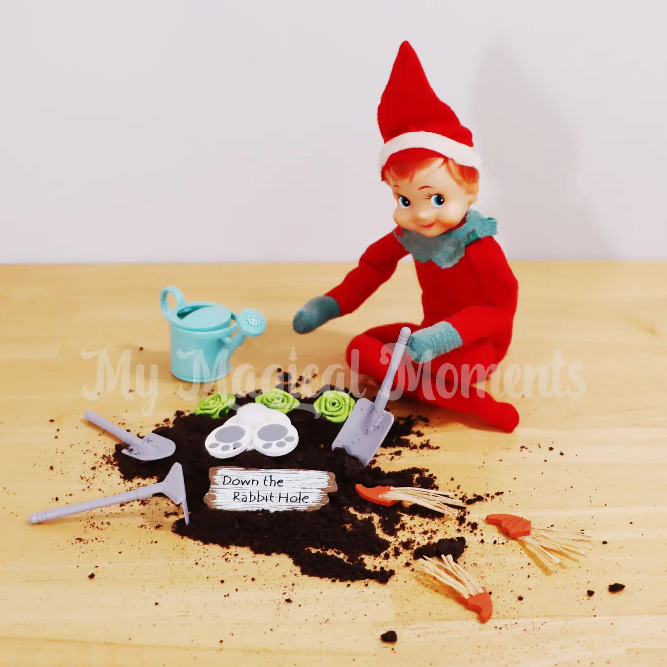 Elf shelf with gardening tools and a 'Down the Rabbit Hole' sign on a wooden surface. with oreo cookie dirt and mini gardening tools,veggie patch and watering can